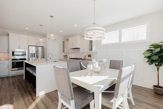 10155 Arrowwood Trl, Woodbury, MN 55129 - dining space with a chandelier, dark wood finished floors, a decorative wall, recessed lighting, and a wainscoted wall