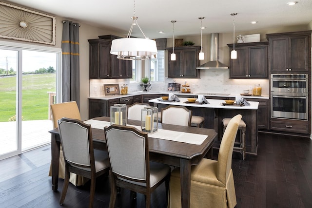 dining room featuring dark wood-style floors, recessed lighting, and a notable chandelier