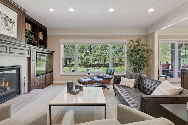 living room with a wealth of natural light, a tiled fireplace, ornamental molding, and recessed lighting