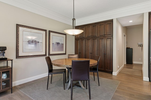 dining room with baseboards, crown molding, recessed lighting, and wood finished floors