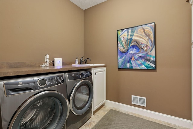 laundry room with baseboards, visible vents, a sink, separate washer and dryer, and cabinet space