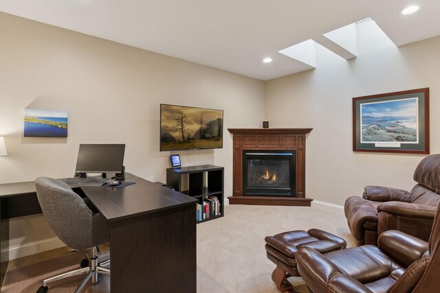 carpeted office with baseboards, a glass covered fireplace, recessed lighting, and a skylight
