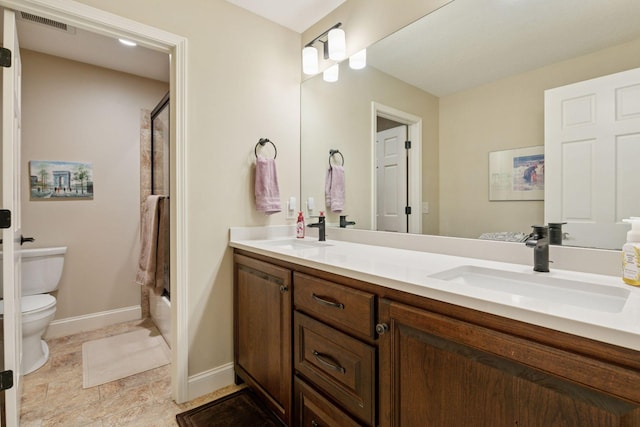bathroom with a sink, double vanity, toilet, and visible vents