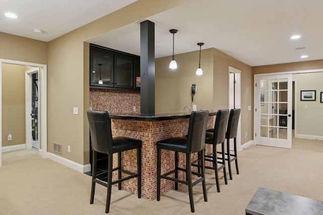 bar with light colored carpet, wet bar, visible vents, and recessed lighting