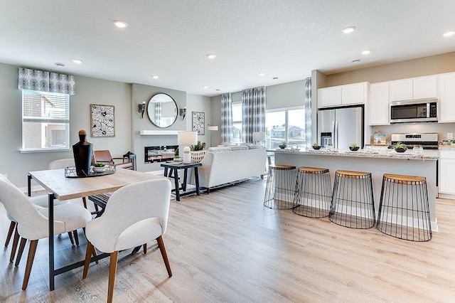 dining area featuring light wood-type flooring and recessed lighting