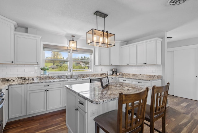4991 337th Ave NE, Cambridge, MN 55008 - kitchen featuring a sink, dark wood-type flooring, a breakfast bar, and decorative backsplash
