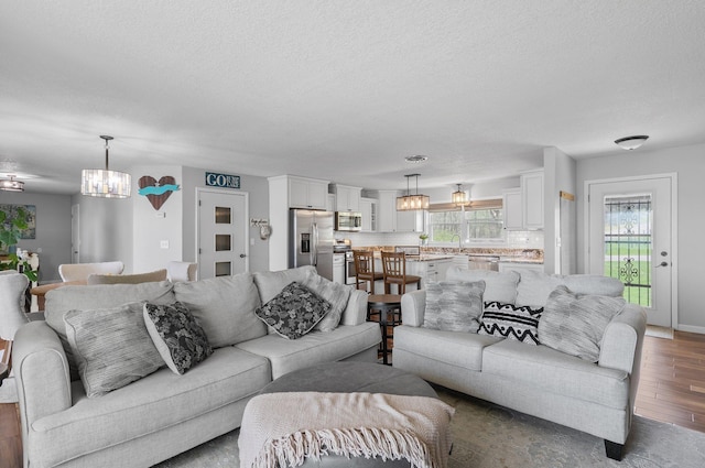 4991 337th Ave NE, Cambridge, MN 55008 - living room featuring wood finished floors, a chandelier, and a textured ceiling