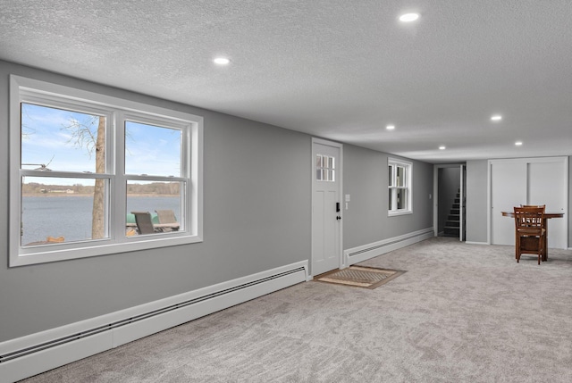 4991 337th Ave NE, Cambridge, MN 55008 - below grade area with a baseboard radiator, recessed lighting, light colored carpet, a textured ceiling, and stairway