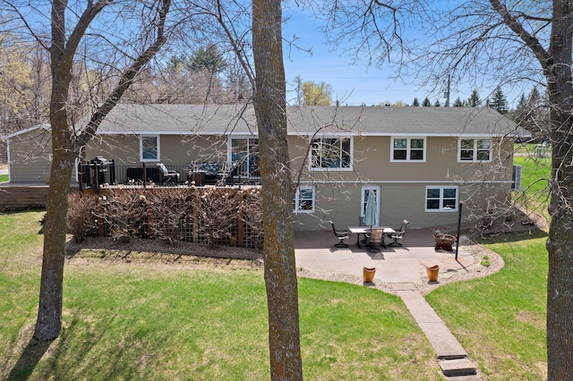 4991 337th Ave NE, Cambridge, MN 55008 - rear view of property featuring stucco siding, a yard, a patio, a shingled roof, and a wooden deck