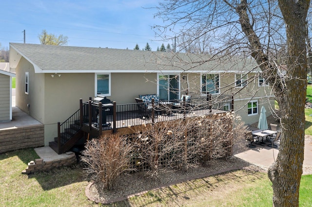 4991 337th Ave NE, Cambridge, MN 55008 - rear view of house with stucco siding, roof with shingles, a deck, and a patio area