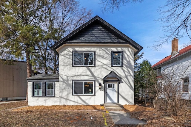 view of front of home featuring roof with shingles and stucco siding