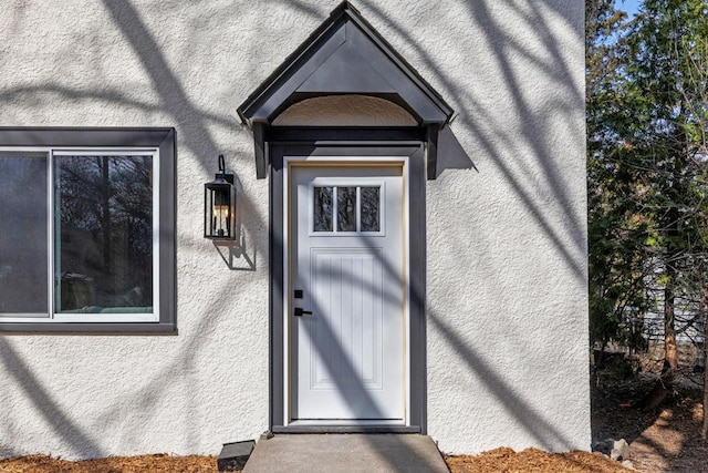 doorway to property featuring stucco siding