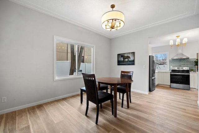 dining area featuring baseboards, a notable chandelier, and light wood finished floors