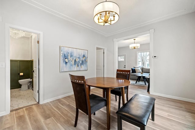 dining area featuring baseboards, an inviting chandelier, and light wood-type flooring