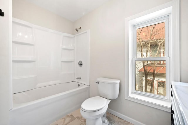 bathroom featuring toilet, bathtub / shower combination, and baseboards