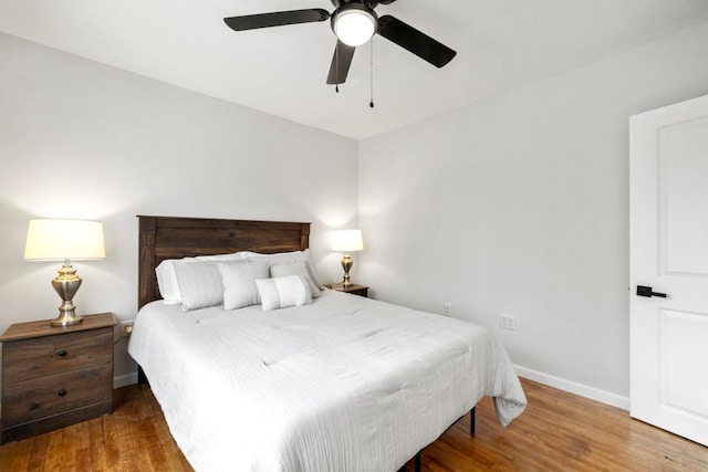 bedroom with baseboards, wood finished floors, and ceiling fan