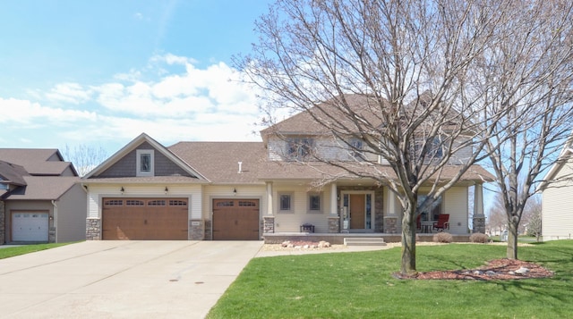 craftsman inspired home with concrete driveway, covered porch, stone siding, a front yard, and a garage
