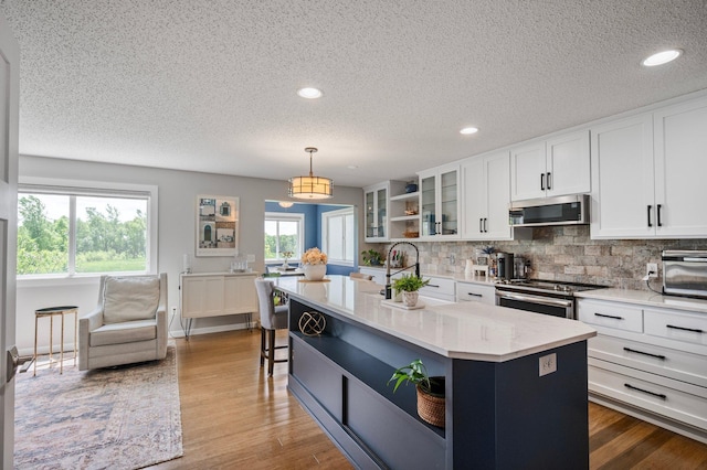 10351 Kittredge Pkwy NE, Otsego, MN 55301 - kitchen featuring stainless steel appliances, open shelves, a textured ceiling, white cabinets, and backsplash