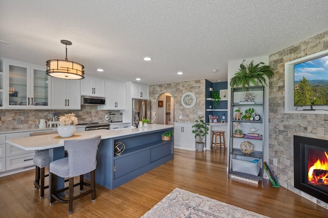10351 Kittredge Pkwy NE, Otsego, MN 55301 - kitchen with appliances with stainless steel finishes, arched walkways, light countertops, white cabinets, and a textured ceiling