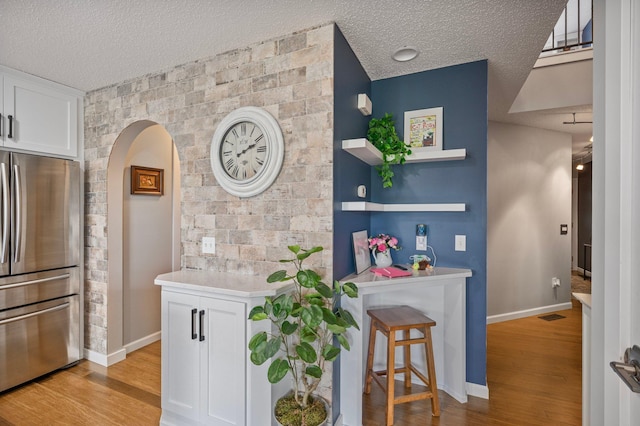 10351 Kittredge Pkwy NE, Otsego, MN 55301 - bar with freestanding refrigerator, a textured ceiling, light wood finished floors, and arched walkways
