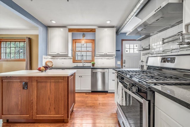 kitchen featuring a sink, decorative backsplash, stainless steel appliances, and a healthy amount of sunlight