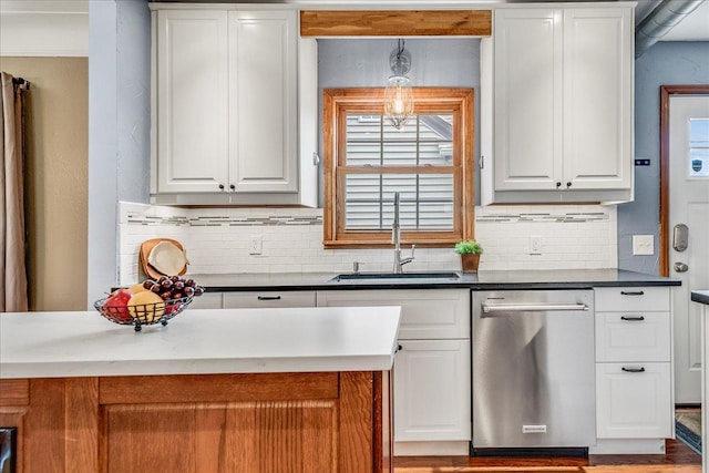 kitchen featuring a sink, decorative backsplash, white cabinetry, and dishwasher
