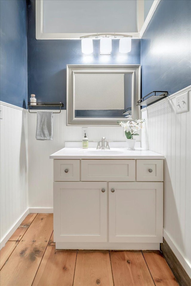bathroom featuring a wainscoted wall, vanity, and wood finished floors
