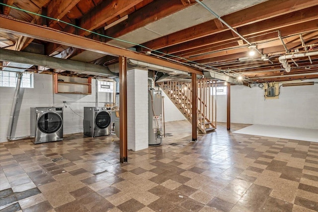 basement featuring stairs, washing machine and dryer, tile patterned floors, electric panel, and gas water heater