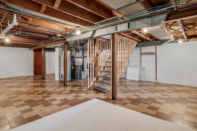 unfinished below grade area featuring water heater, tile patterned floors, heating unit, and stairs