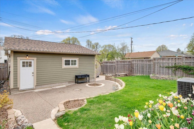 view of yard with a patio, a fenced backyard, a fire pit, and central AC unit