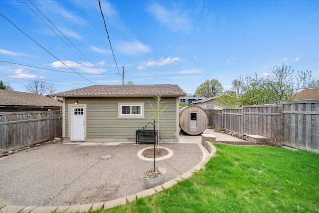 rear view of house featuring a patio, a fenced backyard, and an outdoor structure