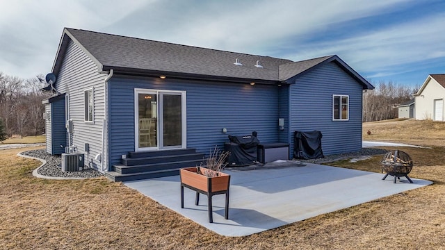 rear view of property with a lawn, an outdoor fire pit, a patio, entry steps, and central AC unit
