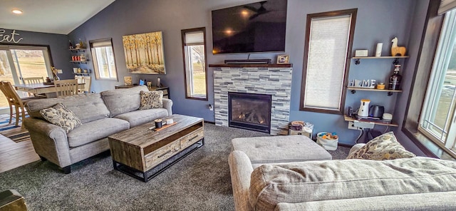 living room with a tile fireplace and lofted ceiling