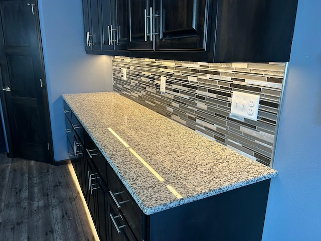 kitchen with decorative backsplash, dark cabinetry, and dark wood finished floors