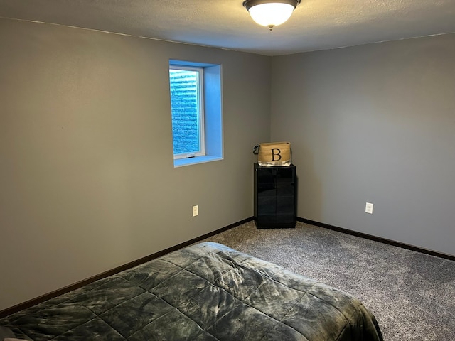 unfurnished bedroom featuring carpet, baseboards, and a textured ceiling