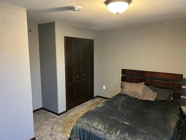 carpeted bedroom featuring a closet, baseboards, and a textured ceiling