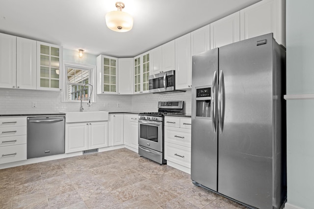 5319 38th Ave S, Minneapolis, MN 55417 - kitchen featuring appliances with stainless steel finishes, a sink, dark countertops, tasteful backsplash, and white cabinetry
