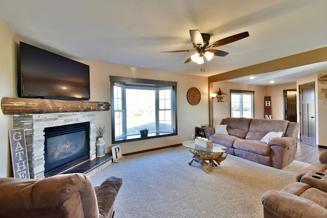 40749 Greencrest Rd, Crow River Twp, MN 56312 - living room with ceiling fan, baseboards, a stone fireplace, and carpet