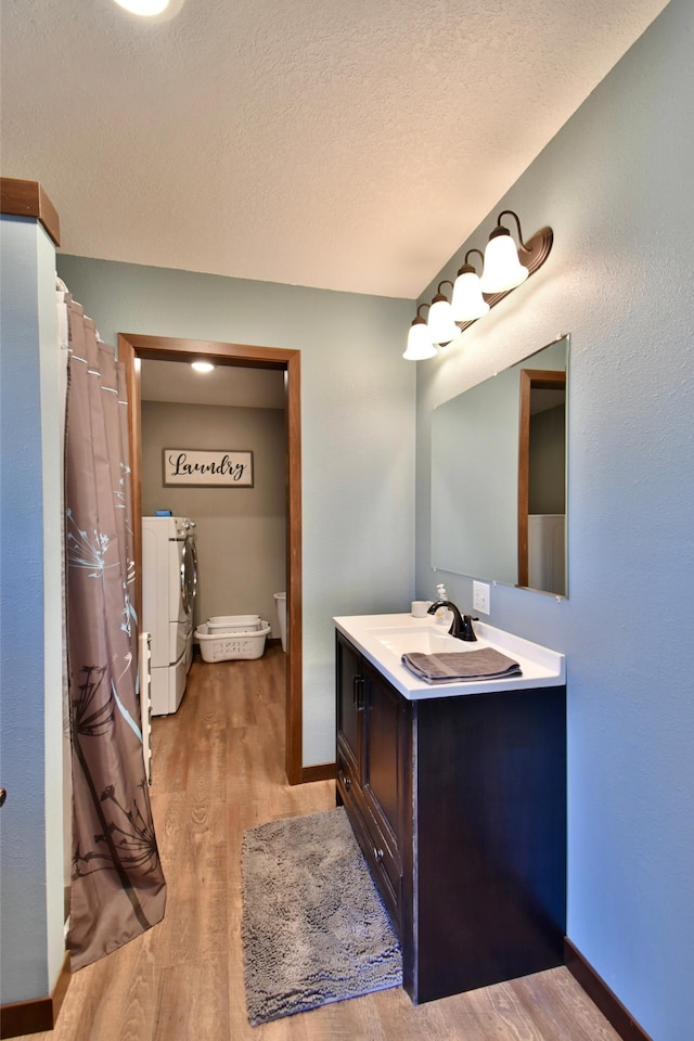 40749 Greencrest Rd, Crow River Twp, MN 56312 - full bath with wood finished floors, vanity, baseboards, and washer and clothes dryer