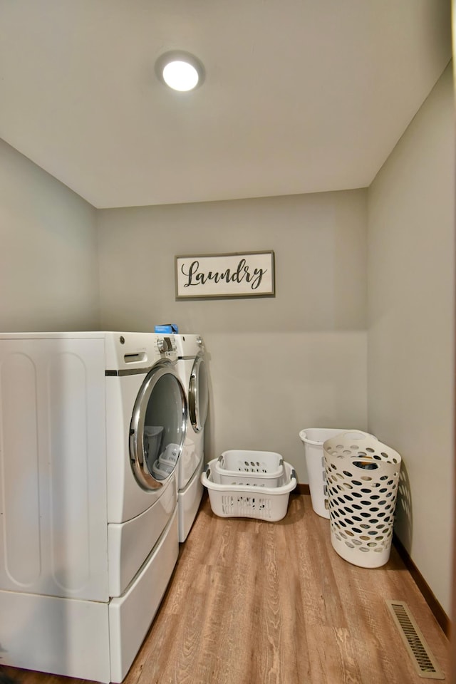 40749 Greencrest Rd, Crow River Twp, MN 56312 - washroom with washing machine and clothes dryer, wood finished floors, visible vents, baseboards, and laundry area