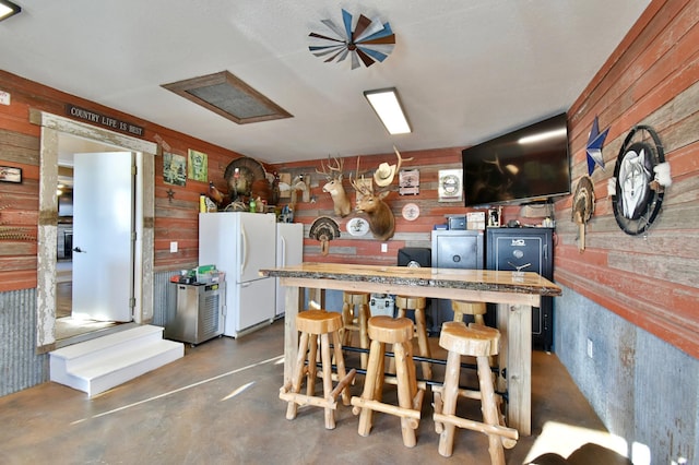 40749 Greencrest Rd, Crow River Twp, MN 56312 - kitchen featuring finished concrete flooring, wood walls, and freestanding refrigerator