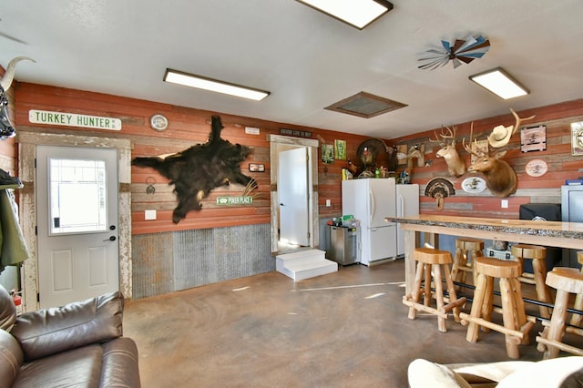 40749 Greencrest Rd, Crow River Twp, MN 56312 - kitchen featuring concrete floors, freestanding refrigerator, and wooden walls