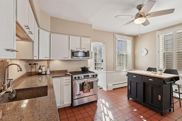 1801 Fremont Ave S Unit 101, Minneapolis, MN 55403 - kitchen featuring stainless steel appliances, a baseboard radiator, a sink, white cabinets, and ceiling fan