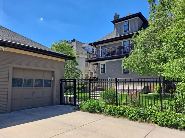 1801 Fremont Ave S Unit 101, Minneapolis, MN 55403 - view of side of home with fence, a garage, concrete driveway, a chimney, and roof with shingles