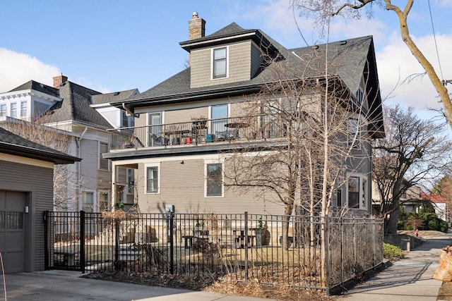 1801 Fremont Ave S Unit 101, Minneapolis, MN 55403 - view of front of house featuring a balcony, a shingled roof, and a chimney