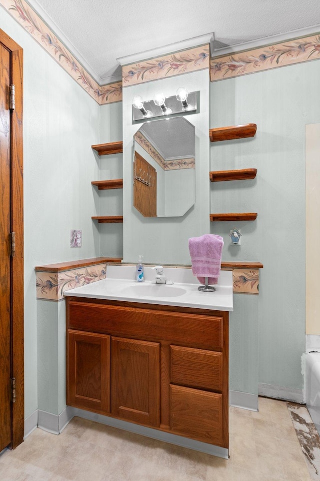 full bathroom featuring a bathing tub, vanity, a textured ceiling, and baseboards