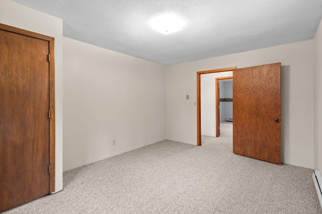 unfurnished room with carpet floors, a baseboard radiator, a textured ceiling, and baseboard heating