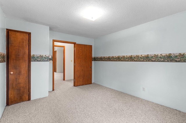 unfurnished room with light carpet and a textured ceiling