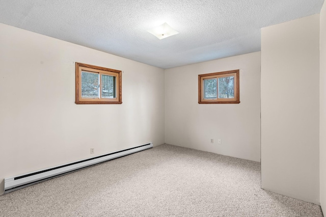 carpeted empty room with baseboard heating and a textured ceiling