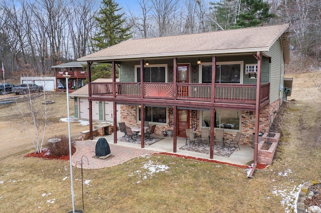 back of property featuring a patio area, a shingled roof, stone siding, and a yard
